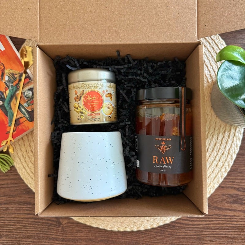 Unwind Gift Box featuring 500g raw honey, Olinda turmeric latte blend with ginger, and ceramic mug in eco-friendly kraft packaging