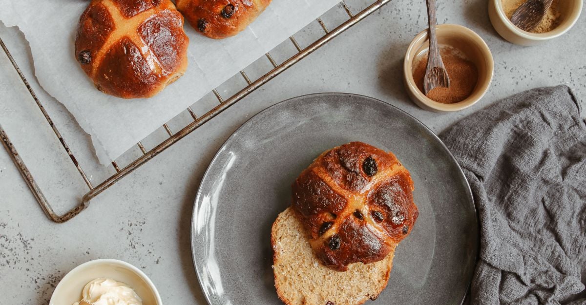 Freshly baked honey and cardamom hot cross buns on a cooling rack
